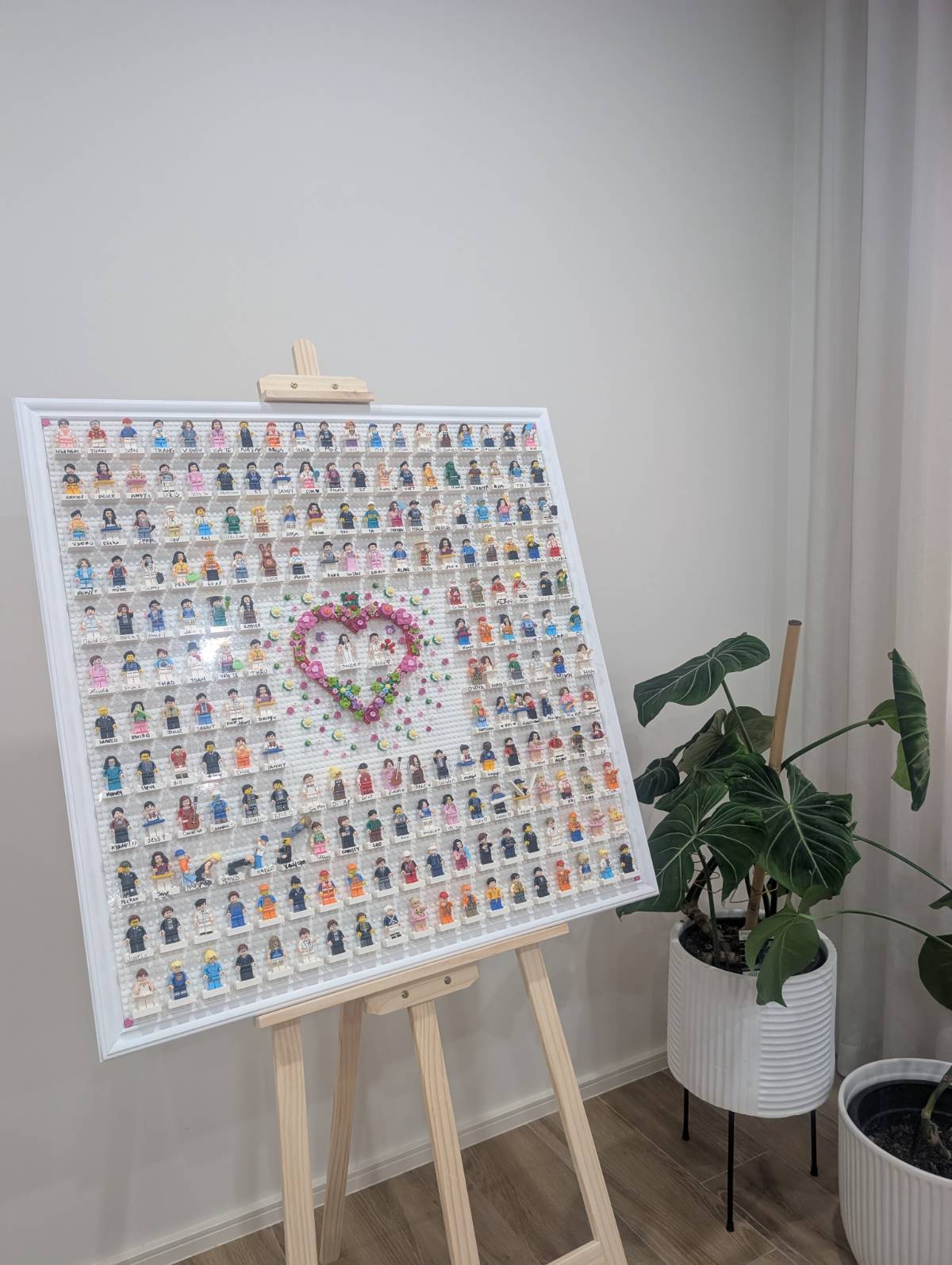 The finished, framed brick guestbook on an easel at home, beside a potted plant.